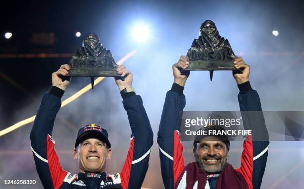 Toyota's Qatari driver Nasser al-Attiyah and French co-driver Mathieu Baumel hold their trophies on the podium after winning the Dakar Rally 2023, at...
