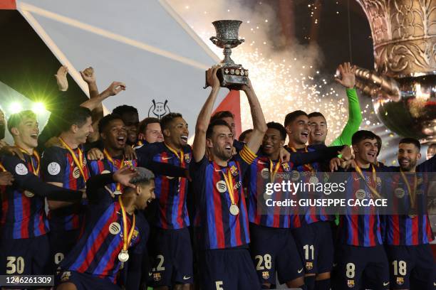 Barcelona's players celebrate on the podium after winning the Spanish Super Cup final football match between Real Madrid CF and FC Barcelona at the...