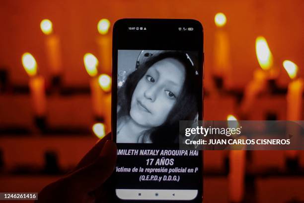 Woman shows a mobile phone displaying the photograph of the late 17 year-old student Yamileth Aroquipa, during a vigil in memory of those killed in...