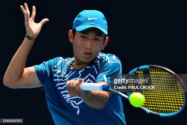 China's Shang Juncheng hits a return against Germany's Oscar Otte during their men's singles match on day one of the Australian Open tennis...