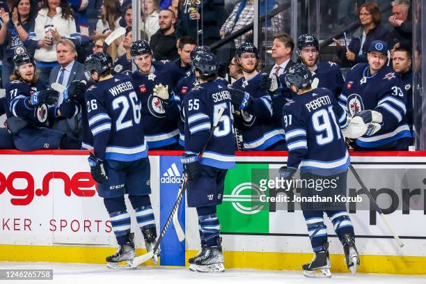 Blake Wheeler, Mark Scheifele and Cole Perfetti of the Winnipeg Jets celebrate a second period goal against the Arizona Coyotes with teammates at the...