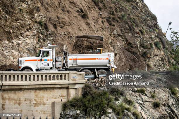 Caltrans workers work to reopen State Route 39 after mudslides and rockslides close the road in both directions near Morris Dam on Sunday, Jan. 15,...