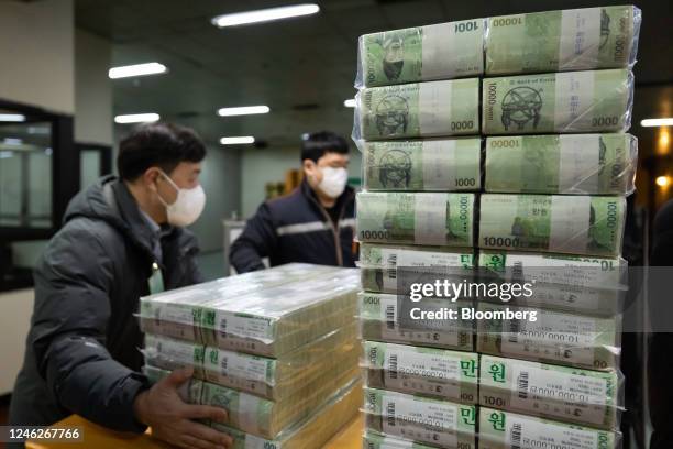 Workers move bundles of South Korean 10,000 won banknotes at the Bank of Korea Gangnam office building in Seoul, South Korea, on Monday, Jan. 16,...