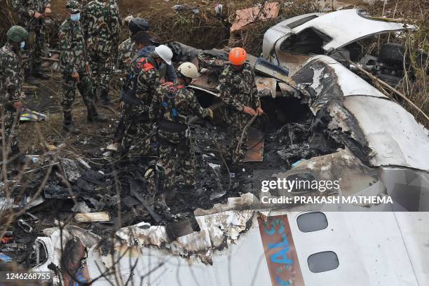 Rescuers inspect the wreckage at the site of a Yeti Airlines plane crash in Pokhara on January 16, 2023. - Nepal observed a day of mourning on...