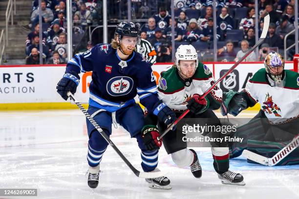 Kyle Connor of the Winnipeg Jets and J.J. Moser of the Arizona Coyotes battle as they follow the play during third period action at the Canada Life...