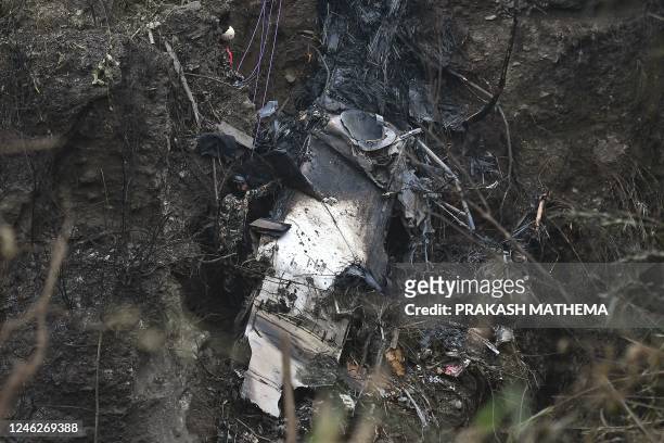 Rescuer inspects the wreckage at the site of a Yeti Airlines plane crash in Pokhara on January 16, 2023. - Nepal observed a day of mourning on...