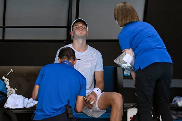 Britain's Jack Draper receives treatment during his men's singles match against Spain's Rafael Nadal on day one of the Australian Open tennis...