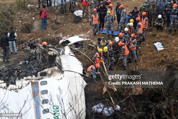 Graphic content / Rescuers pull the body of a victim who died in a Yeti Airlines plane crash in Pokhara on January 16, 2023. - Nepal observed a day...