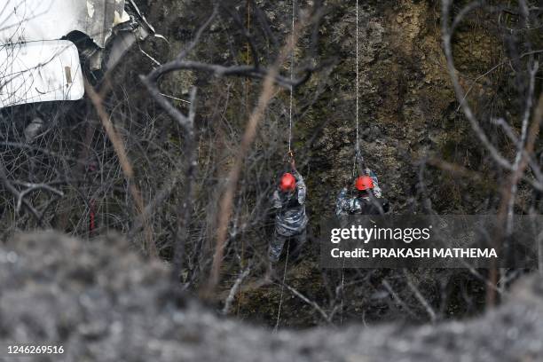 Rescuers inspect the wreckage at the site of a Yeti Airlines plane crash in Pokhara on January 16, 2023. - Nepal observed a day of mourning on...