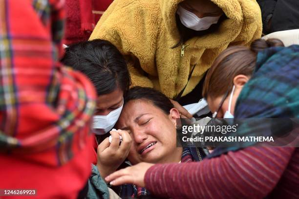 Family members and relatives of victims who died in a Yeti Airlines plane crash, weep outside a hospital in Pokhara on January 16, 2023. - Nepali...