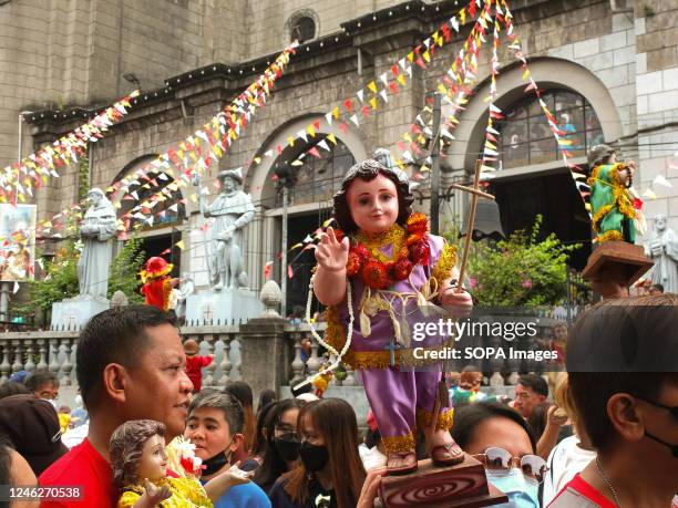 Devotees holding their Señor Santo Niño while waiting for their turn to enter the Santo Niño de Tondo Parish during the feast of Señor Santo Niño in...