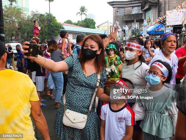 Mother takes selfies with her son and daughters during the feast of Señor Santo Niño in Tondo, Manila. Catholic devotees flock to Santo Niño de Tondo...