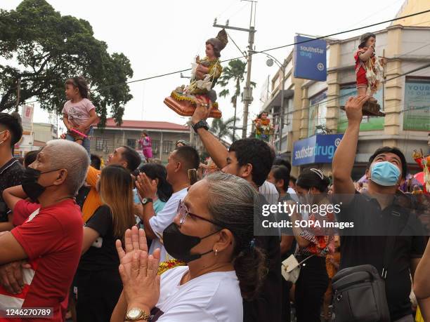 Catholic devotees are raising their Señor Santo Niño replicas in jubilation after the holy mass during the feast of Señor Santo Niño in Tondo,...