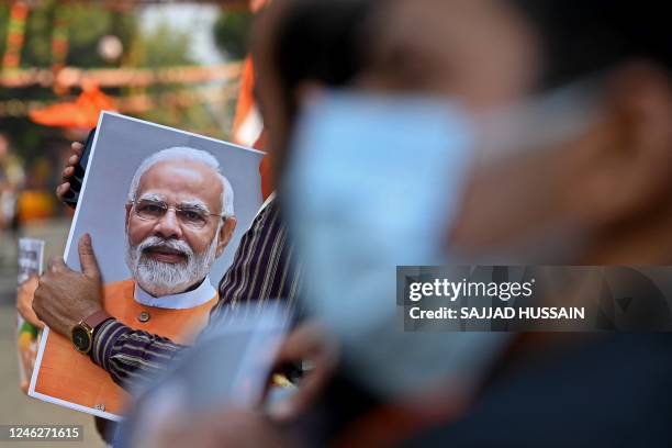 Supporter of the Bharatiya Janata Party holds a picture of India's Prime Minister Narendra Modi during a roadshow ahead of the BJP national executive...