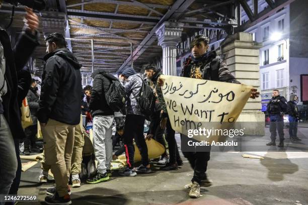 Refugee holds a banner while taking shelter from the cold at the Stalingrad Subway Station in Paris, France on January 11, 2023. Most refugees who...