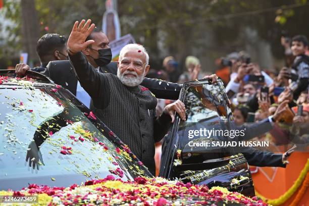 India's Prime Minister Narendra Modi waves to his supporters during a roadshow ahead of the BJP national executive meet in New Delhi on January 16,...