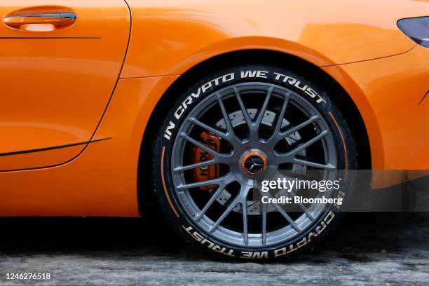 The slogan "In Crypto We Trust" on a tire side wall on a luxury Mercedes-Benz Group AG car ahead of the World Economic Forum in Davos, Switzerland,...