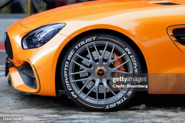 The slogan "In Crypto We Trust" on a tire side wall on a luxury Mercedes-Benz Group AG car ahead of the World Economic Forum in Davos, Switzerland,...