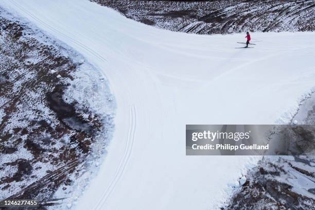 In this aerial view across country skier makes his way along a track of artificial snow on January 16, 2023 near Ehrwald, Austria. Unseasonably warm...