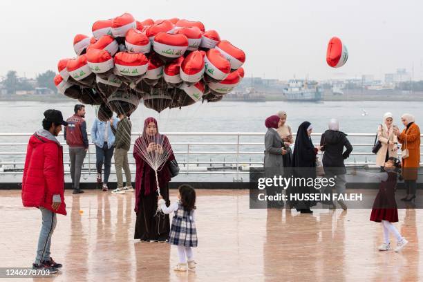 People walk along the Shatt al-Arab river waterfront in Iraq's southern city of Basra on January 14 during the Arabian Gulf Cup. - It is the first...