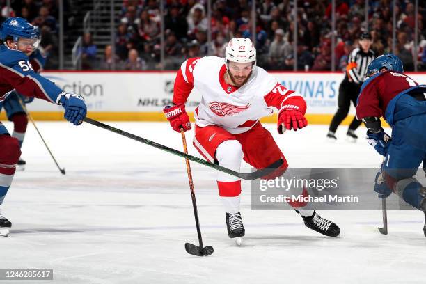 Michael Rasmussen of the Detroit Red Wings skates against Kurtis MacDermid and Evan Rodrigues of the Colorado Avalanche at Ball Arena on January 16,...