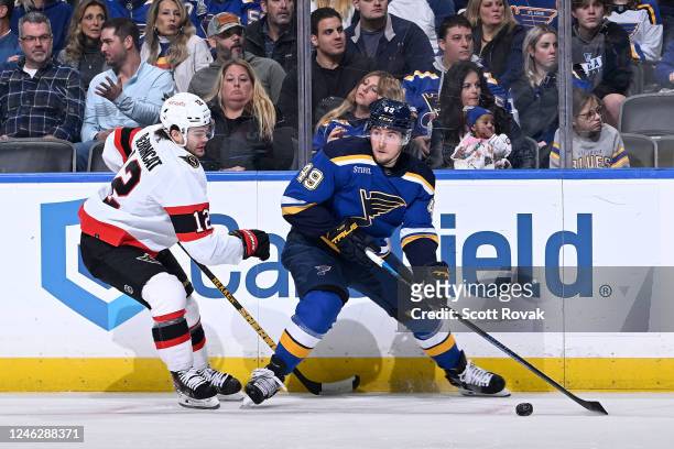Ivan Barbashev of the St. Louis Blues looks to pass as Alex DeBrincat of the Ottawa Senators pressures at the Enterprise Center on January 16, 2023...