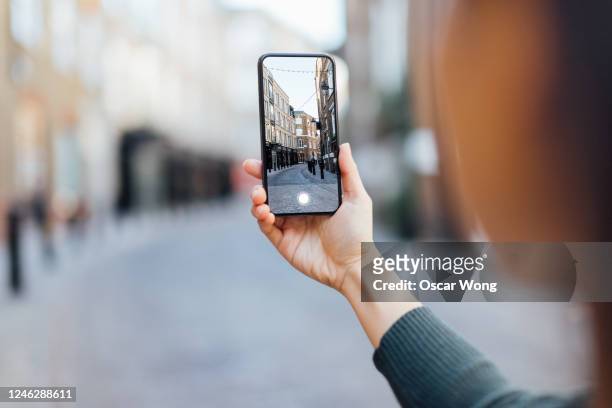tourist capturing city view in london with smartphone - mano umana foto e immagini stock