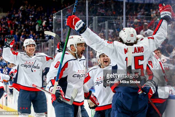 Dmitry Orlov of the Washington Capitals is congratulated by his teammates after scoring the game-winning goal against the New York Islanders in...