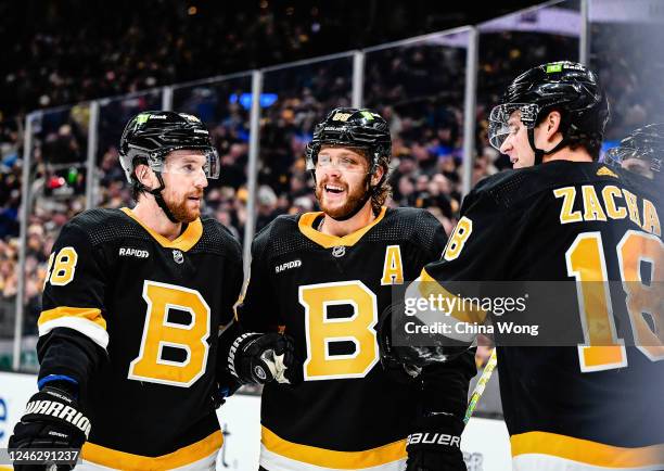 David Pastrnak of the Boston Bruins celebrates with Matt Grzelcyk and Pavel Zacha after scoring a first period goal against the Philadelphia FlyersTD...