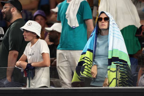 Spectators wait during a suspension due to the rain of the men's singles match between Italy's Fabio Fognini and Australia's Thanasi Kokkinakis on...
