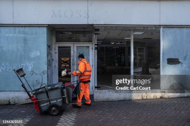 Street cleaner picks up litter from the doorway of a closed down shop in the town centre on January 17, 2023 in Northampton, England. Over 17,000...