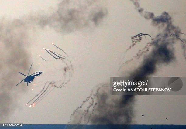 Ukrainian helicopter releases chaff and flare countermeasures as it flies in the vicinity of Bakhmut, Donetsk region on January 17, 2023.