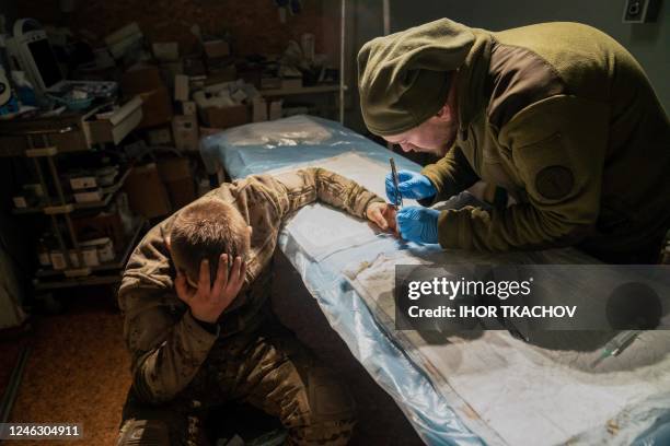 Military doctor operates on a slightly wounded Ukrainian soldier in a stabilisation hospital near the front line in Donetsk region on 17, 2023.