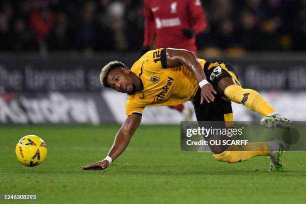 Wolverhampton Wanderers' Spanish midfielder Adama Traore eyes the ball as he falls following a foul commited by Liverpool's Greek defender Kostas...