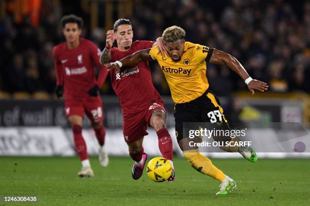 Liverpool's Greek defender Kostas Tsimikas commits a foul on Wolverhampton Wanderers' Spanish midfielder Adama Traore as they fight for the ball...