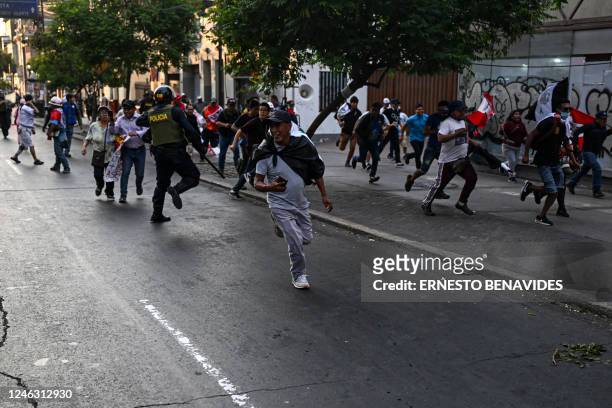 People clash with the police while protesting against the government of Peruvian President Dina Boluarte in Lima on January 17, 2023. - Peruvian...