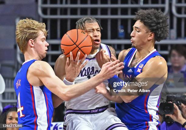 Keyontae Johnson of the Kansas State Wildcats battles for the ball against Gradey Dick and Jalen Wilson of the Kansas Jayhawks, in the first half at...