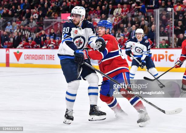 Pierre-Luc Dubois of the Winnipeg Jets and Jordan Harris of the Montreal Canadiens skate against each other during the first period at Centre Bell on...