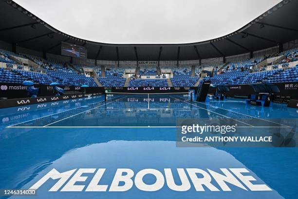 General view shows a wet court as rain falls on day three of the Australian Open tennis tournament in Melbourne on January 18, 2023. - -- IMAGE...