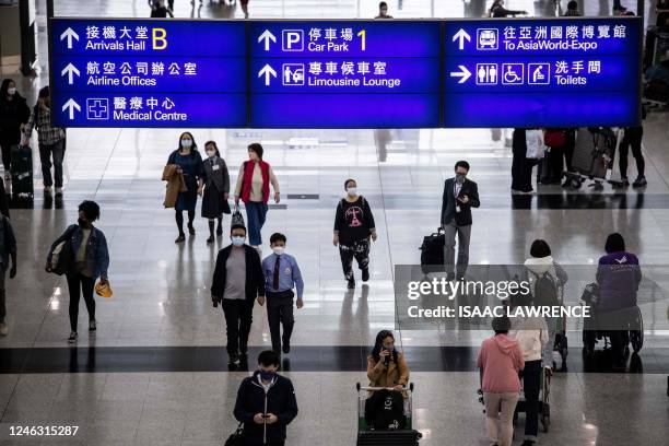 This picture taken on January 5, 2023 shows people walking through the arrivals hall at Hong Kong International Airport. - Regional airlines are...