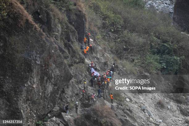 Nepal army, Police, AFP Rescuers recover the body of a victim who died in a Yeti Airlines plane crash in Pokhara. A Yeti Airlines plane crashed on...