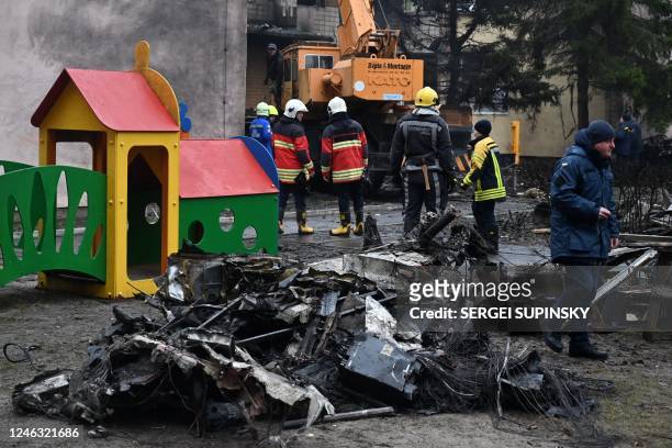 Firefighters work near the site where a helicopter crashed near a kindergarten in Brovary, outside the capital Kyiv, killing Sixteen people,...