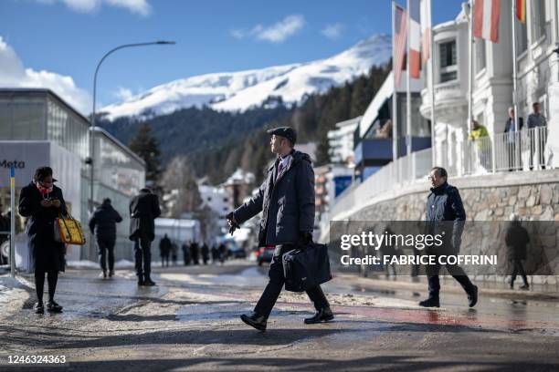 Participants walk in the street of the Alpine resort of Davos during the World Economic Forum annual meeting in Davos on January 18, 2023.