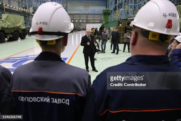Russian President Vladimir Putin speaks during his meeting with workers at the Obukhov State Plant as a military vehicle with pro-war propaganda...
