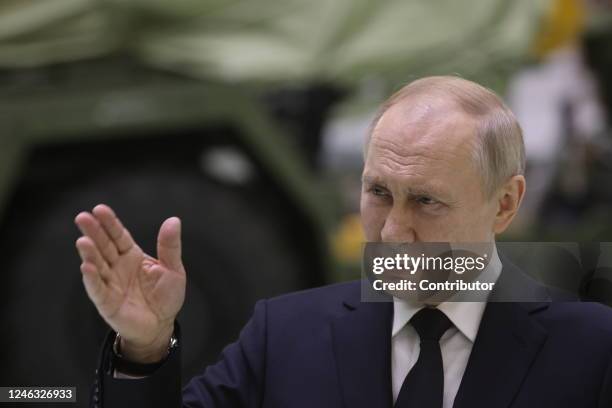 Russian President Vladimir Putin speaks during his meeting with workers at the Obukhov State Plant as a military vehicle seen in the background on...