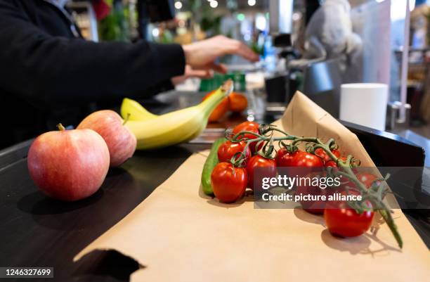 January 2023, Bavaria, Neubiberg: Foodstuffs lie on the conveyor belt at the checkout in a supermarket. Under the impact of high inflation, consumer...