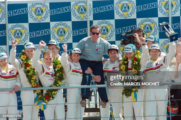 French manager of the Peugeot Talbot team Jean Todt is carried in triumph by the drivers of the three Peugeot 905 which won the 61st edition of the...