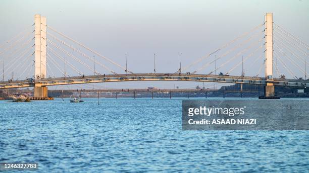 This picture taken on January 18, 2023 shows a view of the Hadarat bridge across the Euphrates river, whose water levels have risen after recent...
