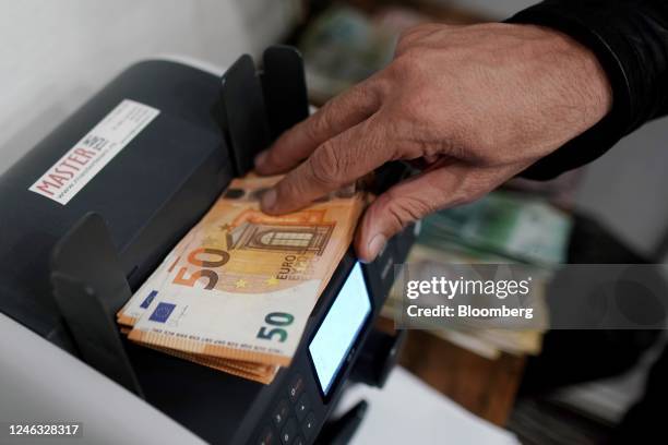 An employee places 50 euro banknotes in a counting machine in a currency exchange office in Belgrade, Serbia, on Thursday, Jan. 17, 2023. Serbia,...