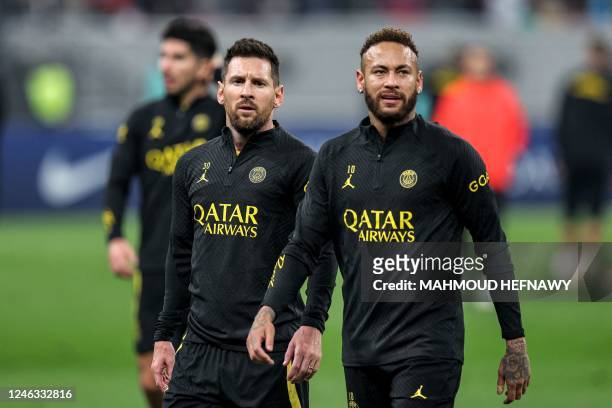 Paris Saint-Germain's Brazilian forward Neymar and Argentine forward Lionel Messi walk together during a team training session at Khalifa...